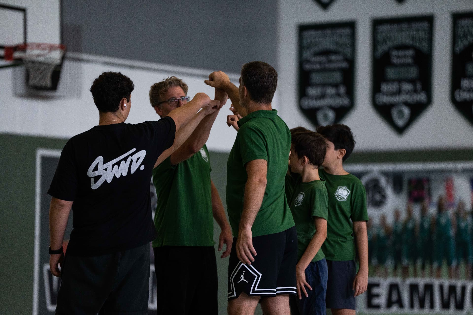 Coaches and campers joining a team huddle