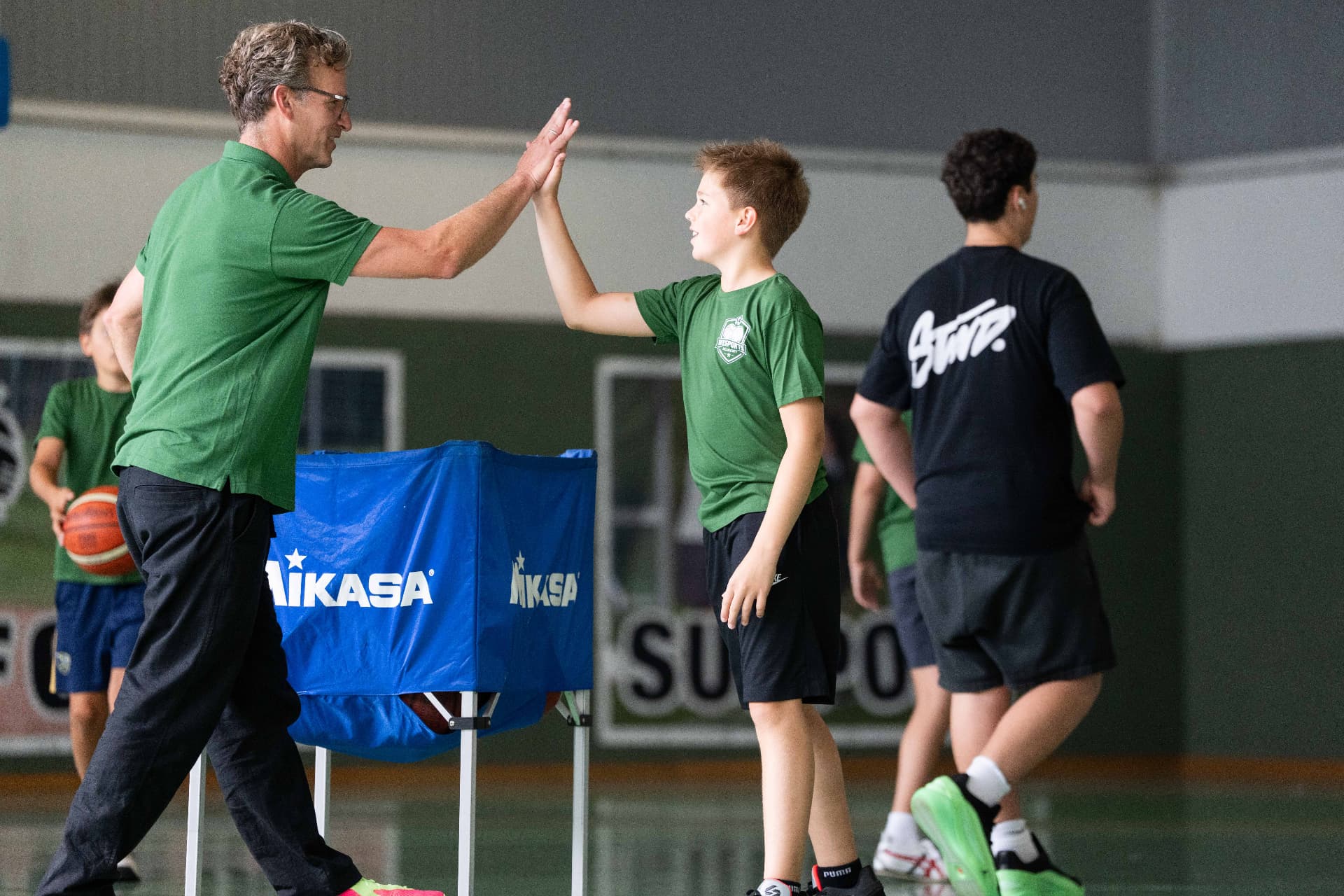 Coach and camper celebrating during basketball camp